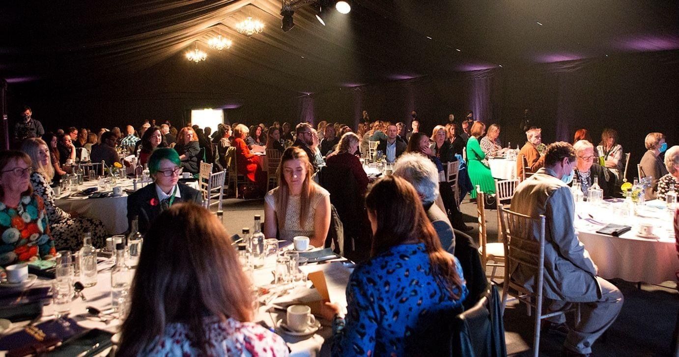 Large event with people seated at tables, likely a banquet or gala.