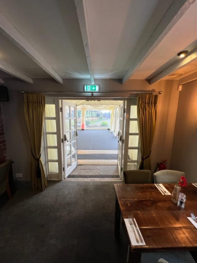 Interior doorway with open doors leading outside, seen from inside a restaurant.