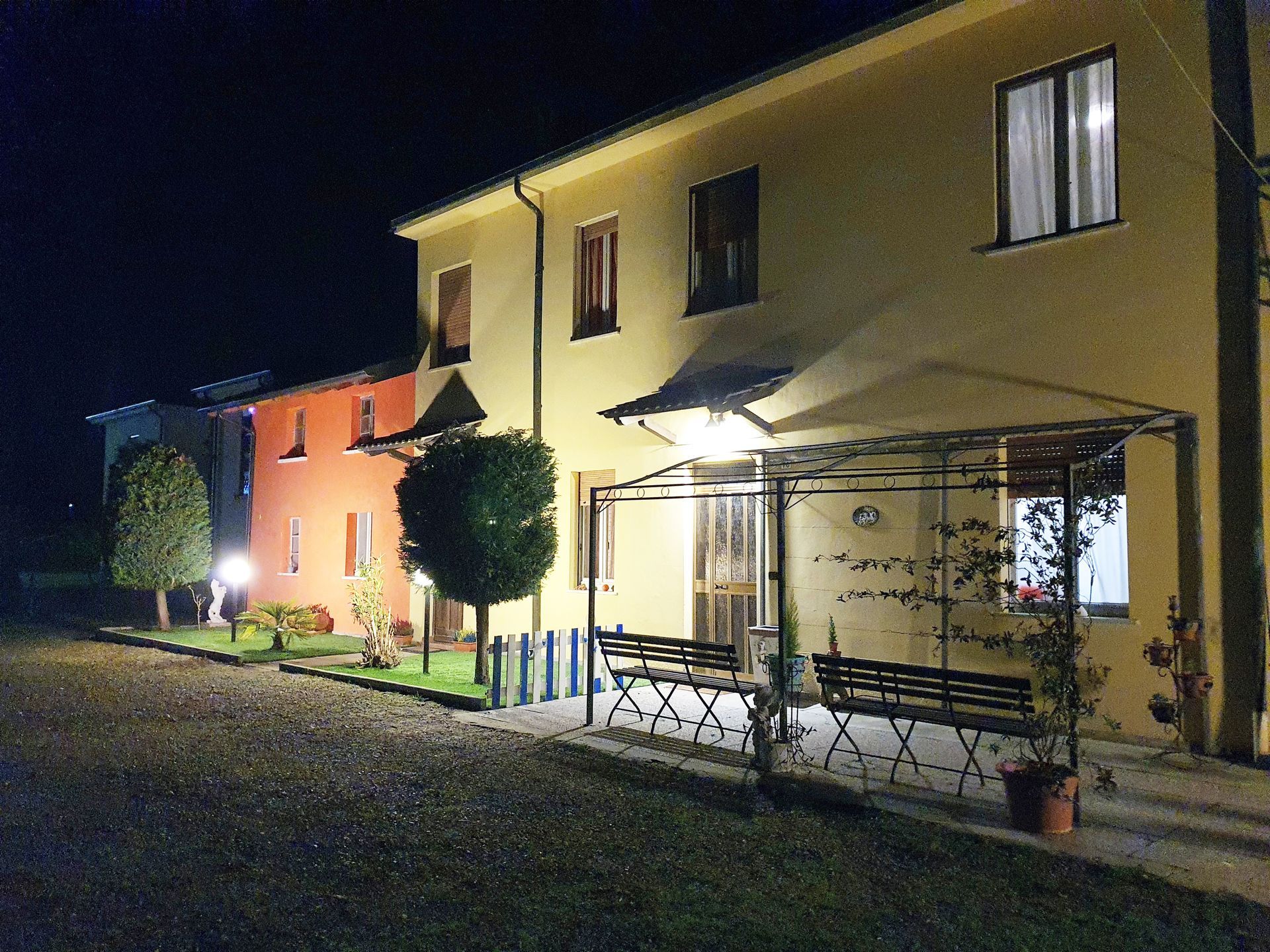 Esterno degli edifici di notte, con portico illuminato e pareti colorate.