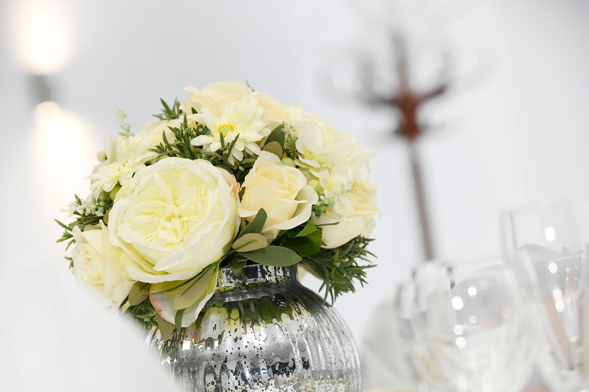 A vase filled with white flowers is on a table.