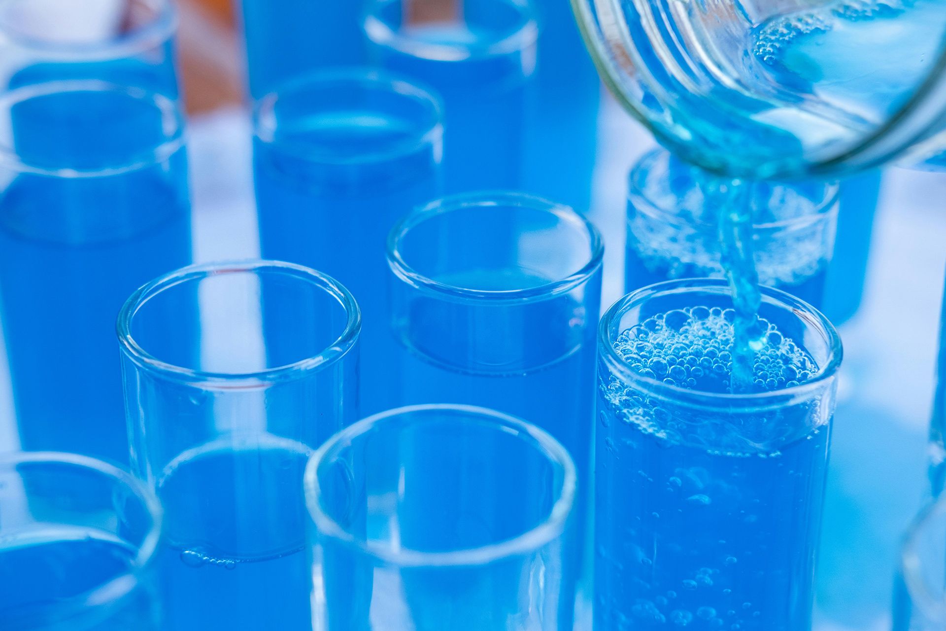 Blue liquid being poured into test tubes.