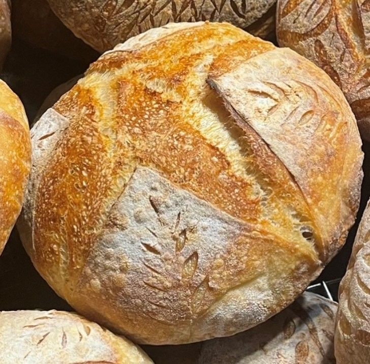 A loaf of bread is surrounded by other loaves of bread
