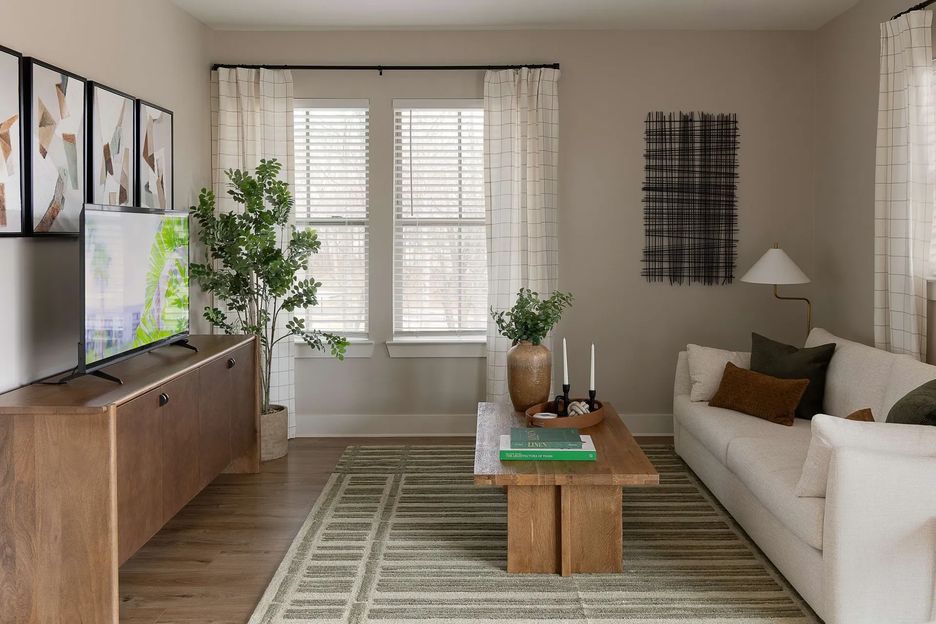 Modern living room with a sectional sofa, coffee table, television, and decorative art.