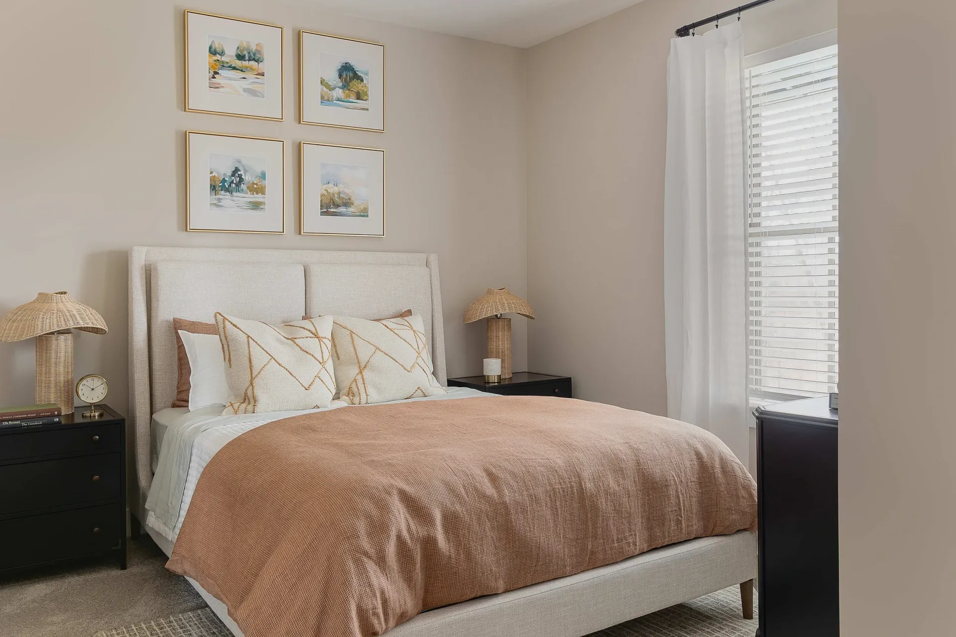 Cozy bedroom with a queen-sized bed, neutral decor, and artwork.