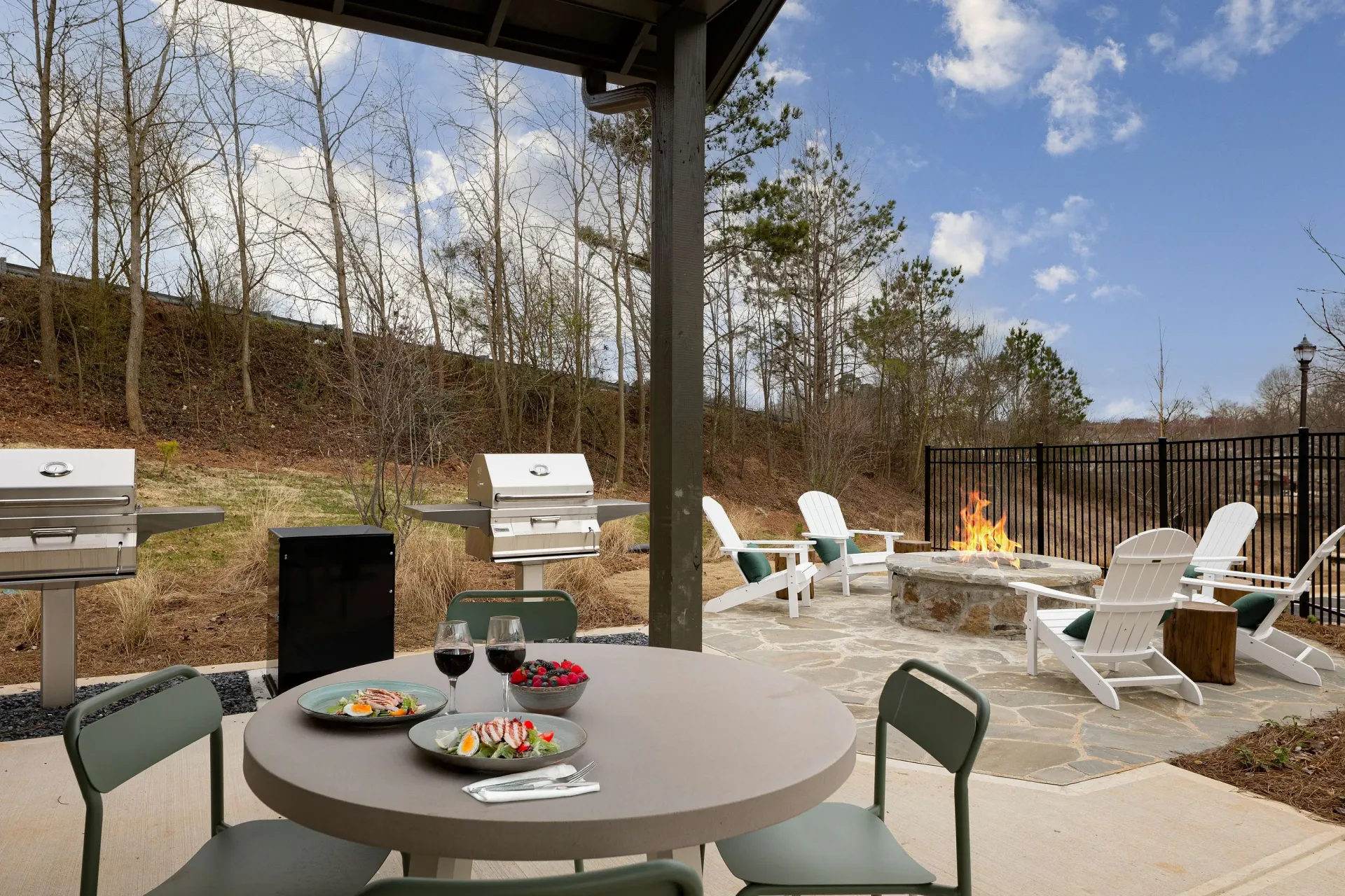 Outdoor grilling area with grills, fire pit, and seating.