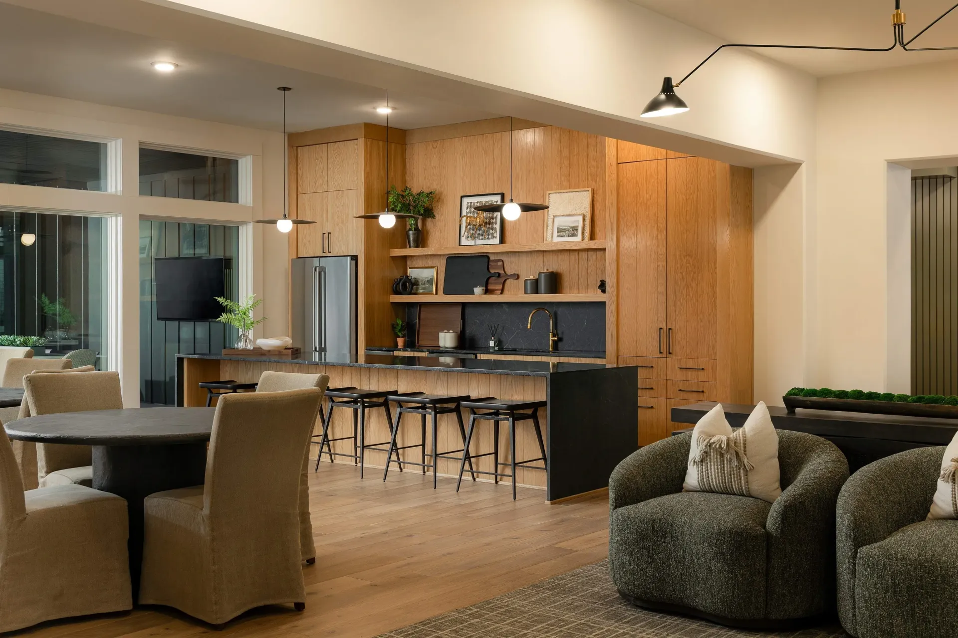 Modern communal kitchen and lounge area with island seating and comfortable chairs.