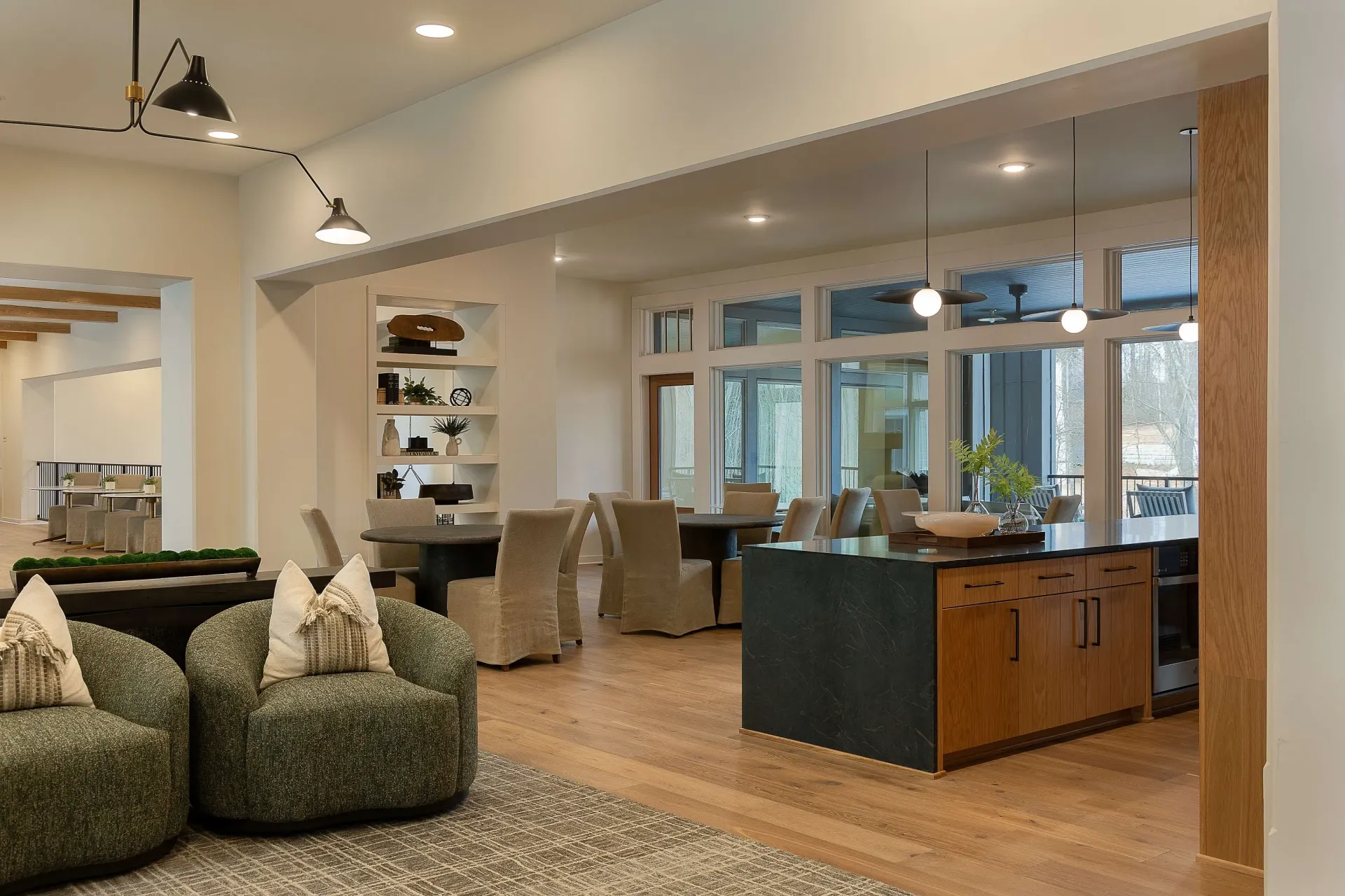 Modern community lounge area with seating, dining tables, and a kitchen island.