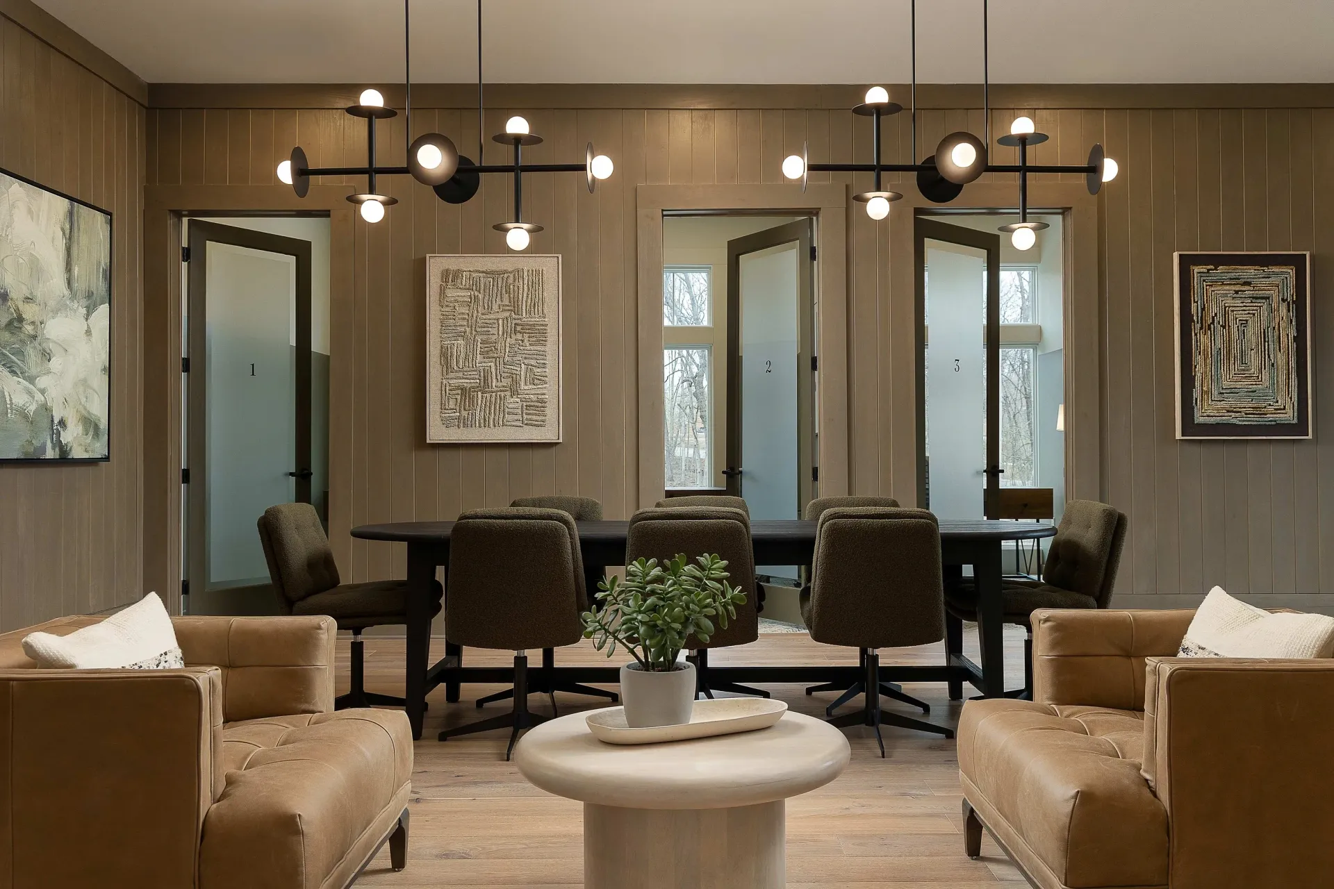 Modern conference room with a large table, chairs, and artwork.
