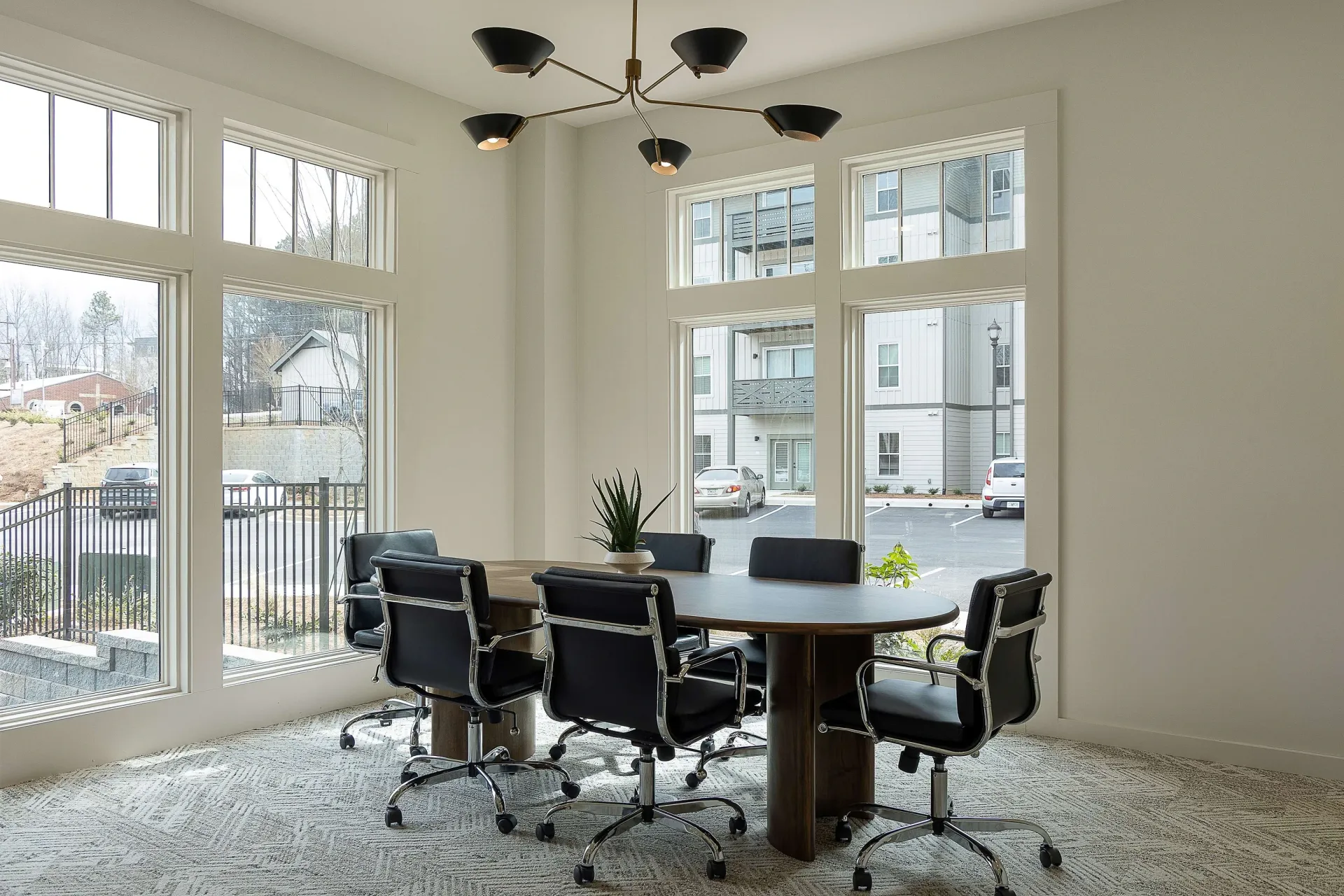 Conference room with a large oval table and executive chairs.
