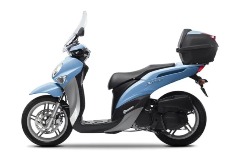 A blue scooter with a black luggage rack on the back.