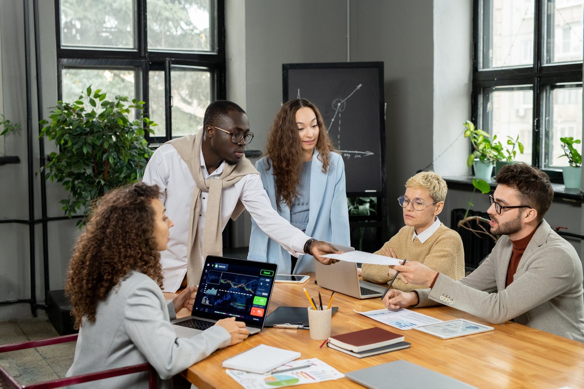 A group of people are sitting around a table having a meeting.