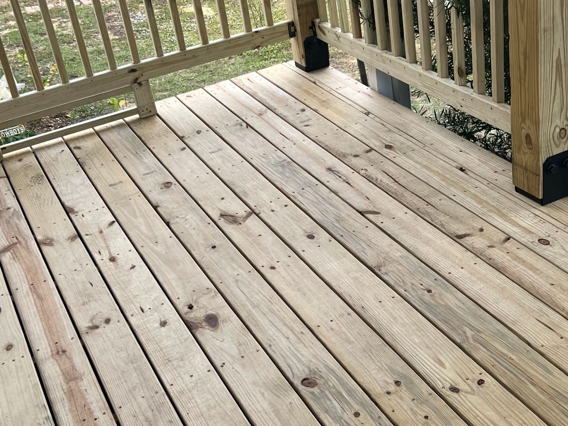 Wooden deck with railings and a small black lantern near the corner