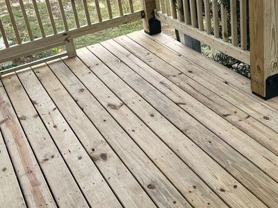 Wooden deck with railings and a small black lantern near the corner