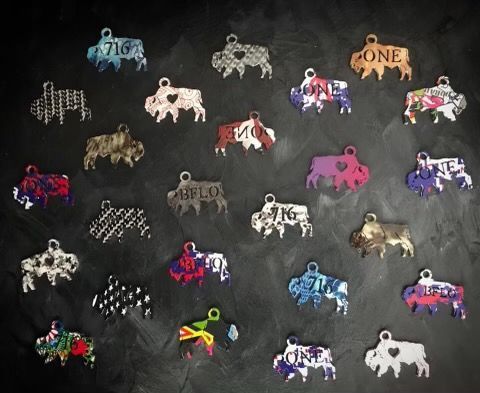 Assorted bison-shaped ornaments in various colors, patterns, and designs, displayed against a dark, textured background.