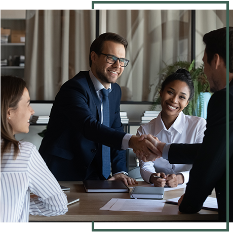 A group of people are sitting around a table shaking hands. A group of people are sitting around a table shaking hands.