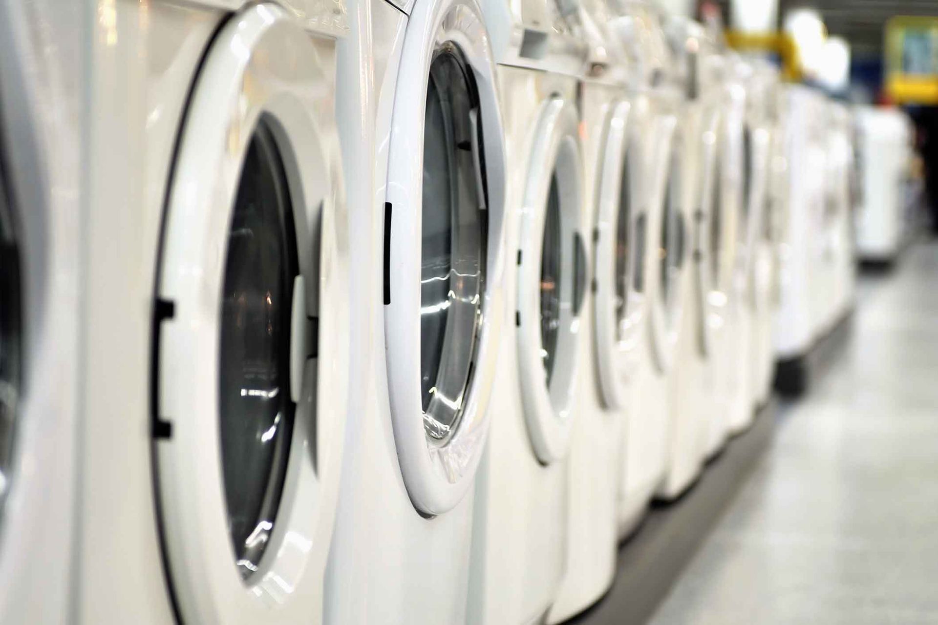 A Row Of White Washing Machines Are Lined Up In A Laundromat – Margate, QLD - Ocean Breeze Dry Cleaners