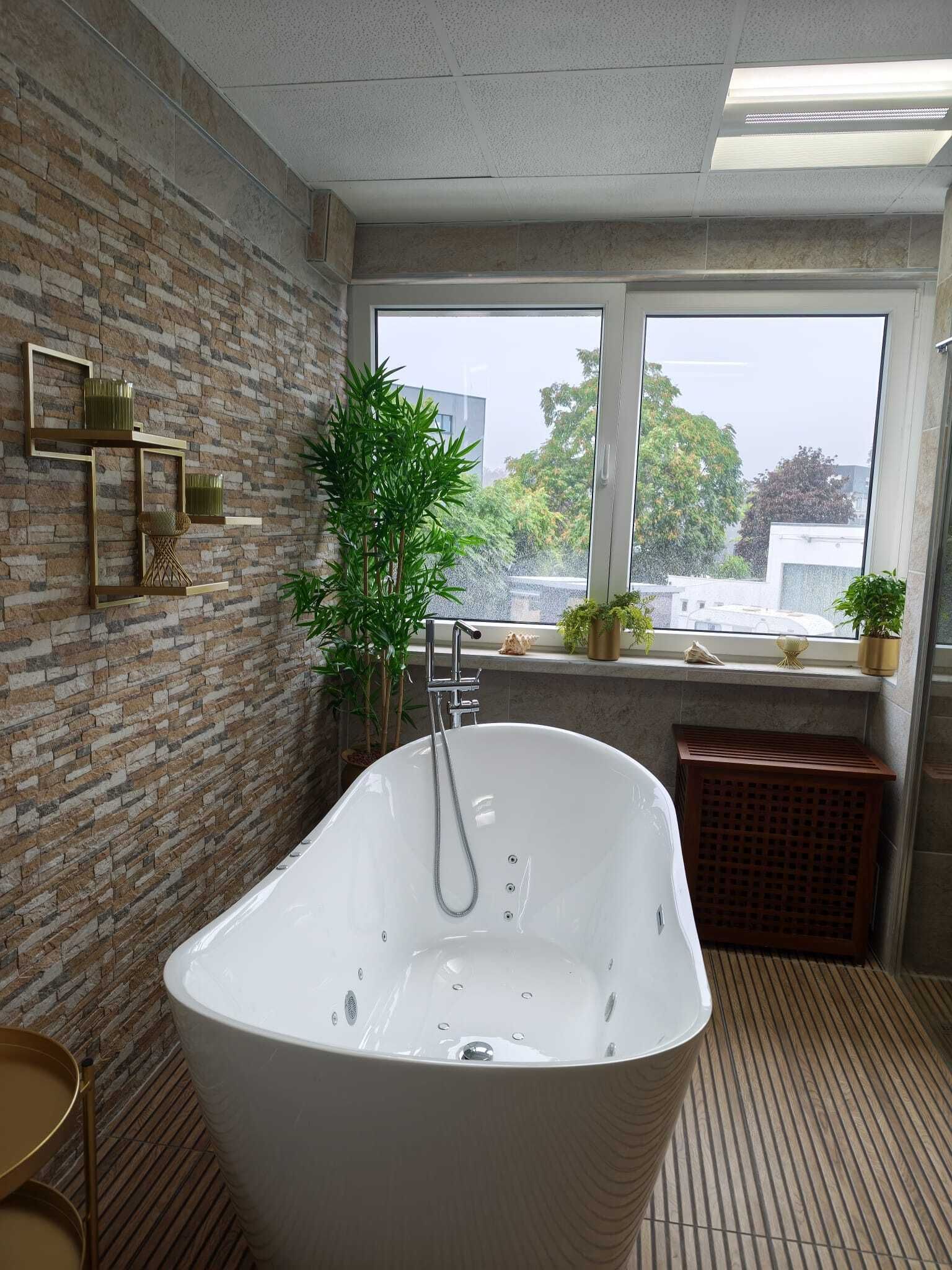 Modernes Badezimmer mit einer freistehenden weißen Badewanne, einer Backsteinwand