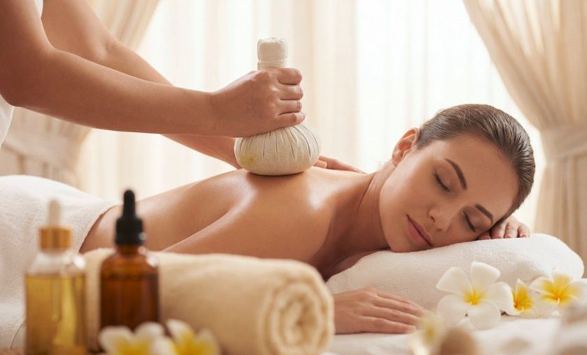 Wellnessmassage mit einer Frau, die auf dem Bauch liegt
