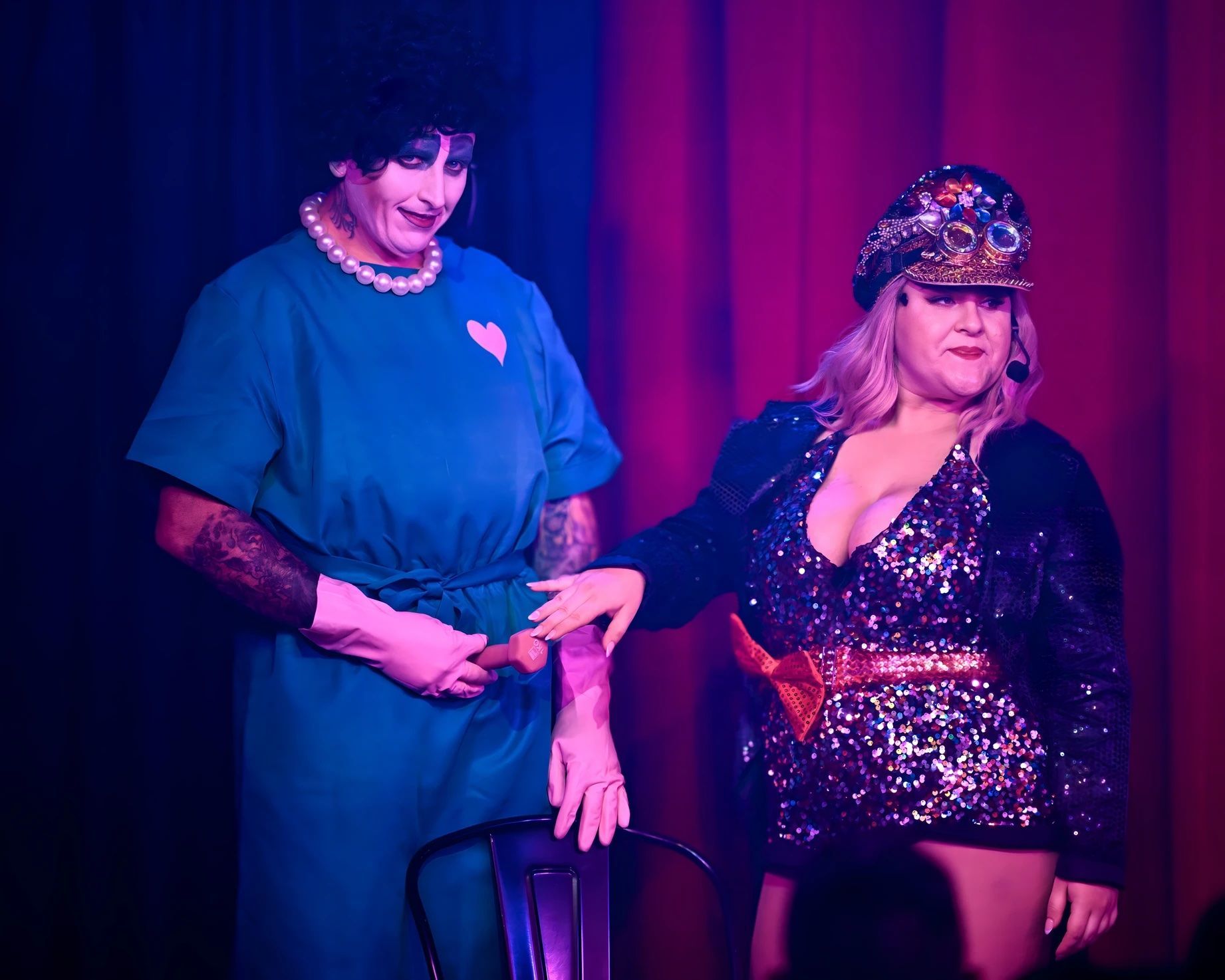 A Woman In A Red Feathered Outfit Is Holding A Fan — Lux Noir In  Mackay, QLD