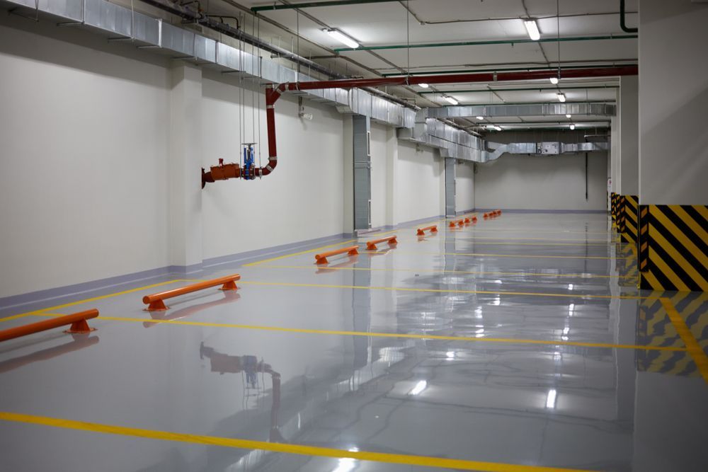 Empty Parking Garage With A Concrete Floor And Yellow Lines — Diamond Concreting In Mount Low, QLD