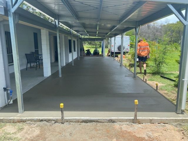Man Laying Concrete On The Ground With A Shovel — Diamond Concreting In Mount Low, QLD