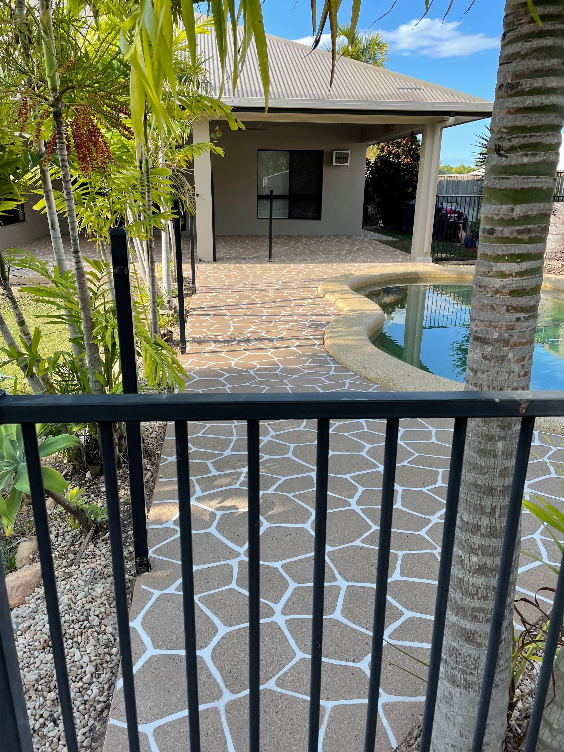 Man Laying Bricks On A Patio With A Hammer And A Level — Diamond Concreting In Mount Low, QLD