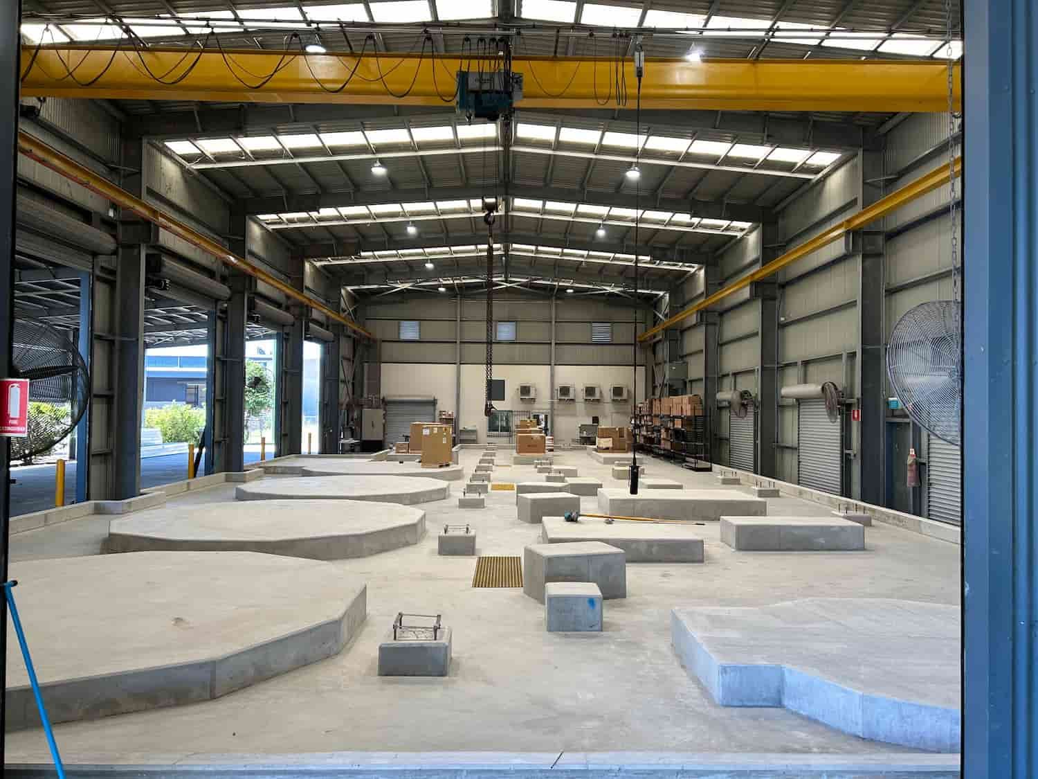 A Large Warehouse With a Crane in the Middle of It — Diamond Concreting In Mount Low, QLD