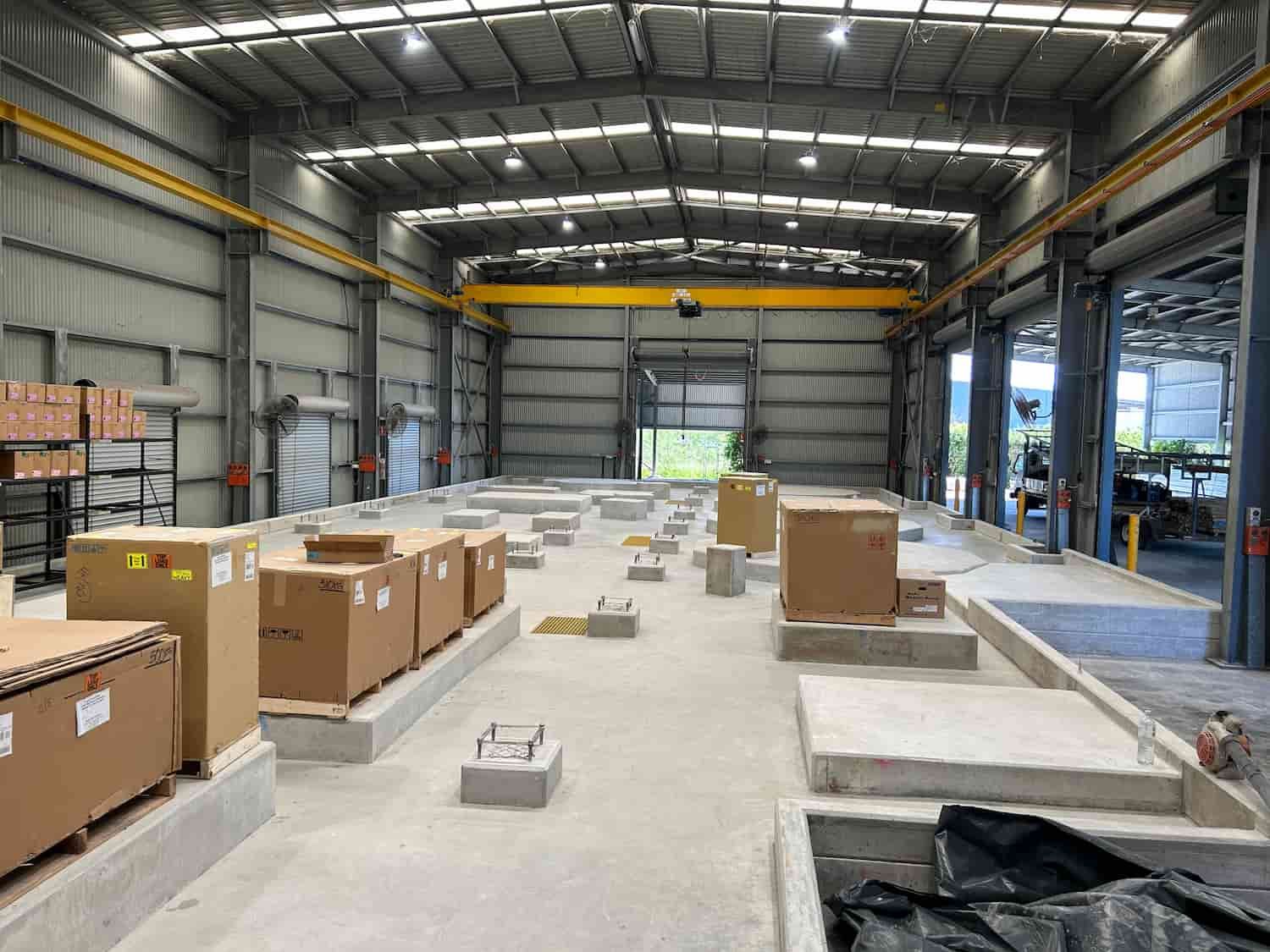 A Large Warehouse Filled With Lots of Boxes and a Crane — Diamond Concreting In Mount Low, QLD