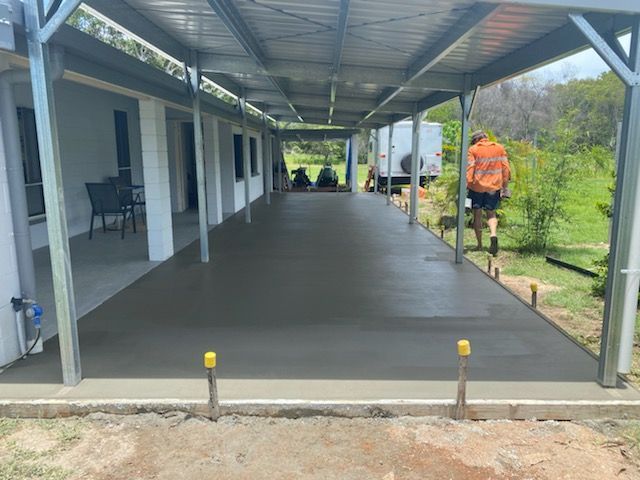 Man Working On A Concrete Driveway Under A Canopy — Diamond Concreting In Mount Low, QLD