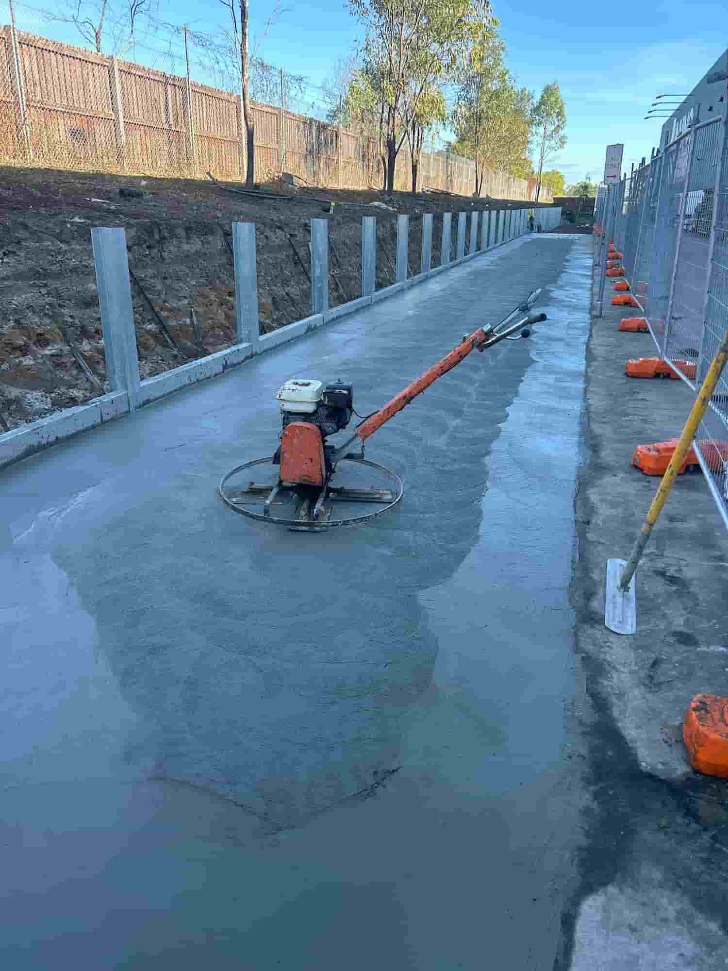 A Person is Using a Trowel to Spread Concrete on a Sidewalk — Diamond Concreting In Mount Low, QLD