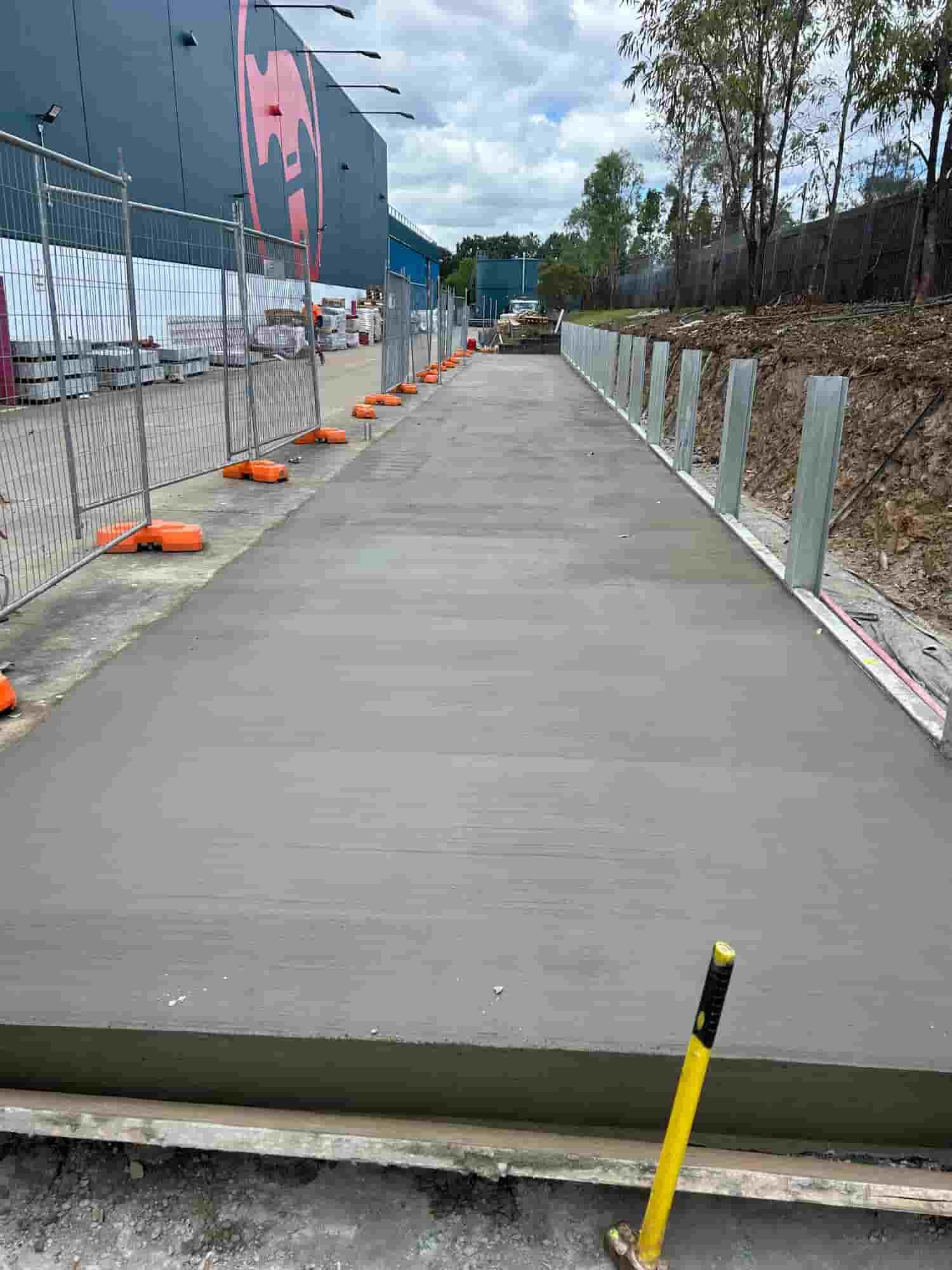 A Concrete Walkway is Being Built Next to a Fence — Diamond Concreting In Mount Low, QLD