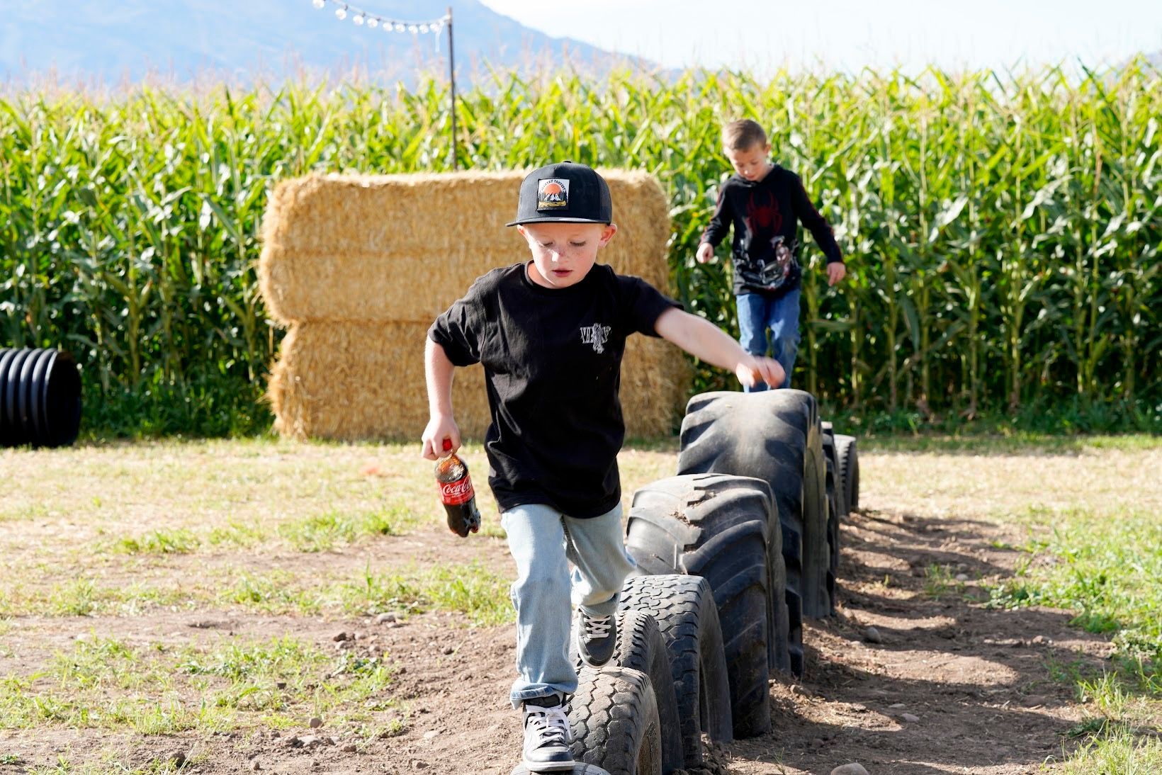 Kids playing in tire playground at corn maze near me farm fun in Northern Utah