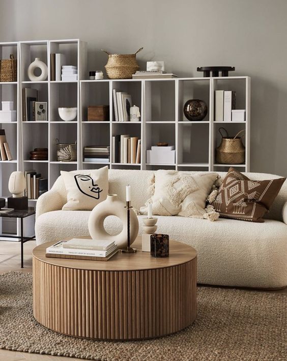 A living room with a couch , coffee table , and shelves.