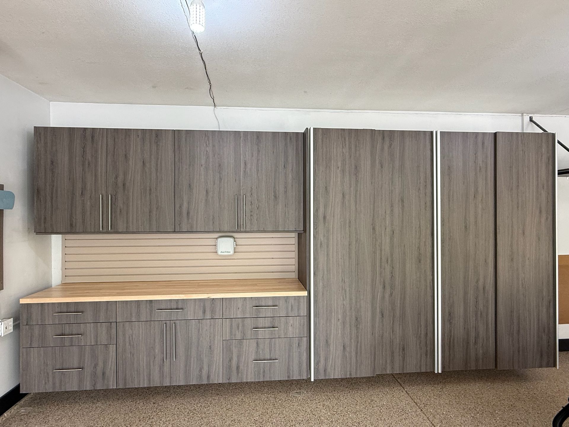 Wooden wall of cabinets with a built-in desk niche in an empty room