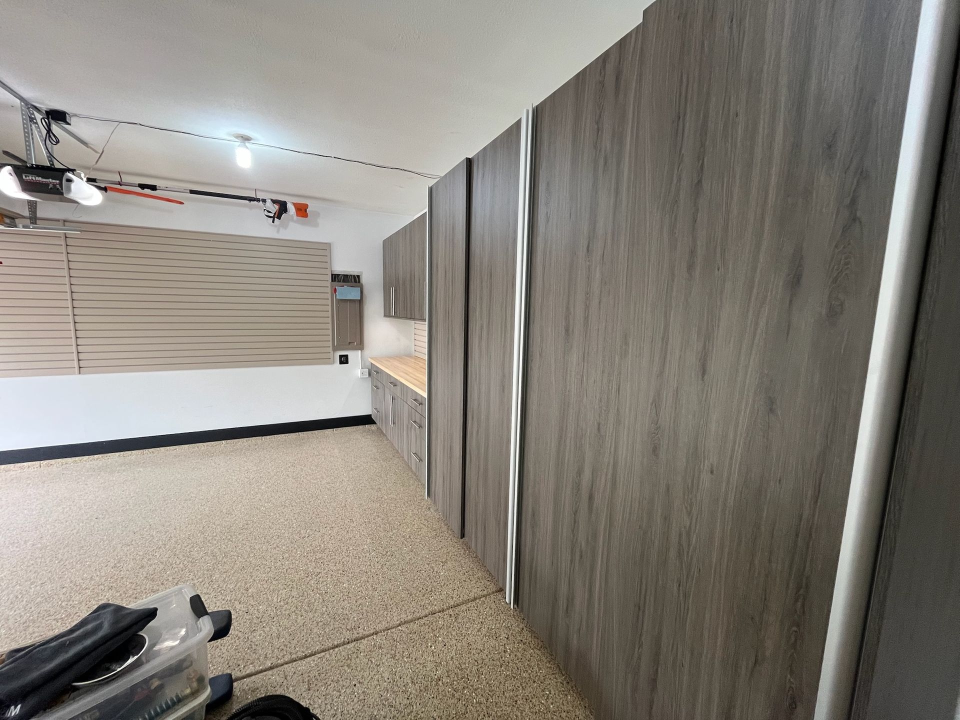 Indoor showroom with gray wood cabinets, beige floor, and a work light near a display wall