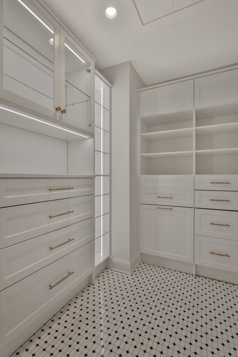 A walk in closet with lots of drawers and shelves