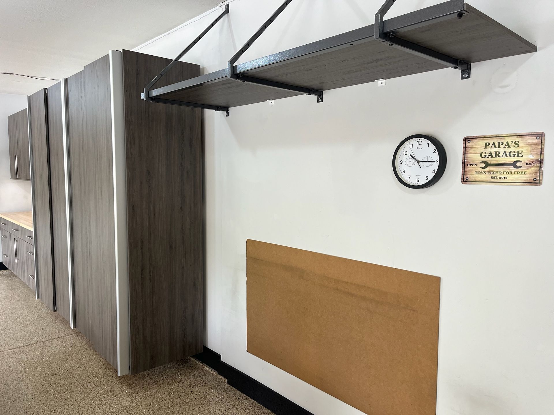 Indoor hallway with wood-paneled wall, clock, sign, and overhead awning supports