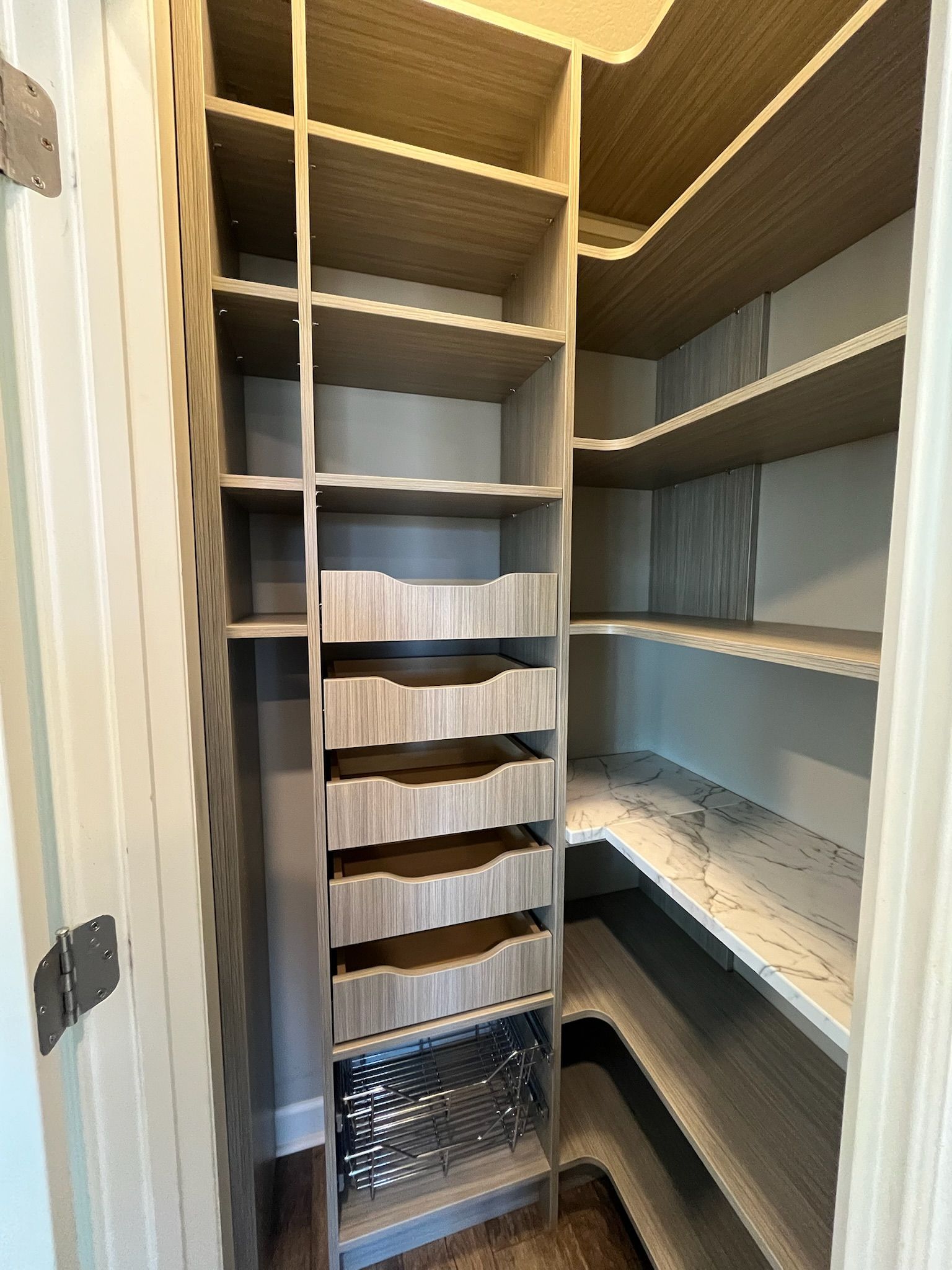 Walk-in closet with gray shelves, hanging rods, and built-in drawers