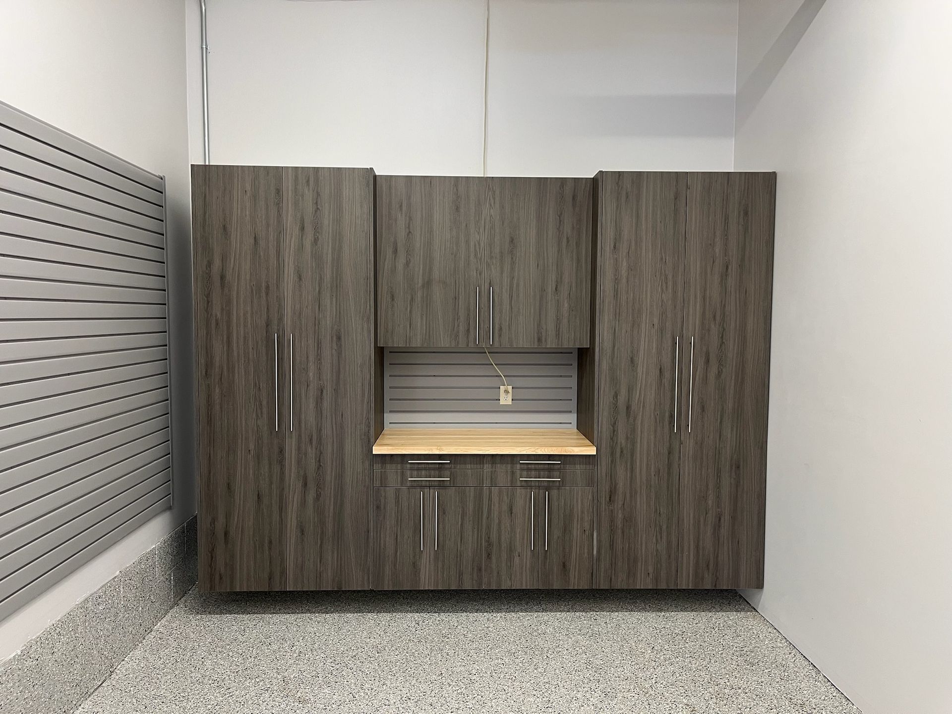 Gray wood cabinets with a small built-in counter in an empty room