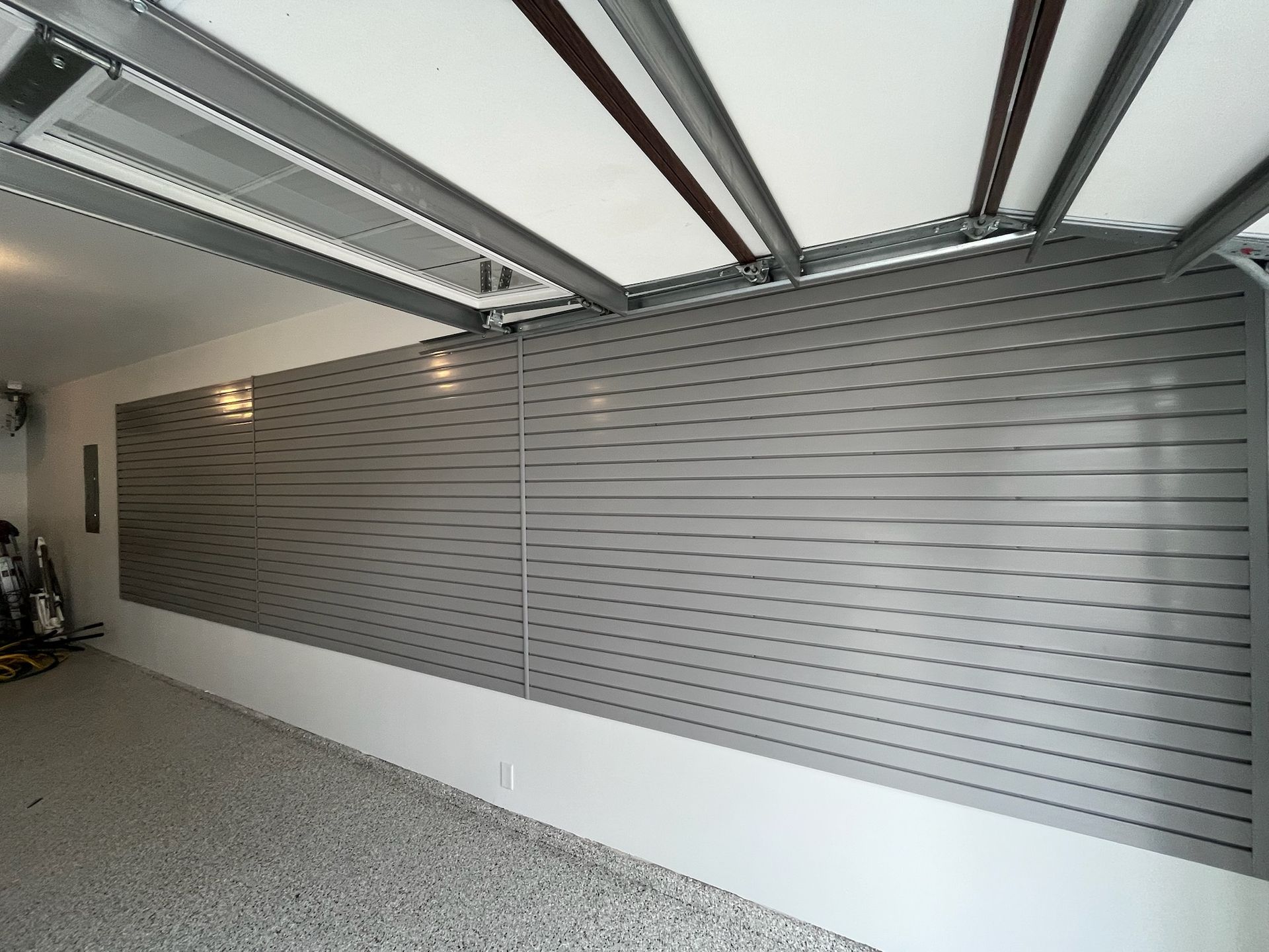 Modern garage interior with slatted gray wall panels and skylight ceiling.