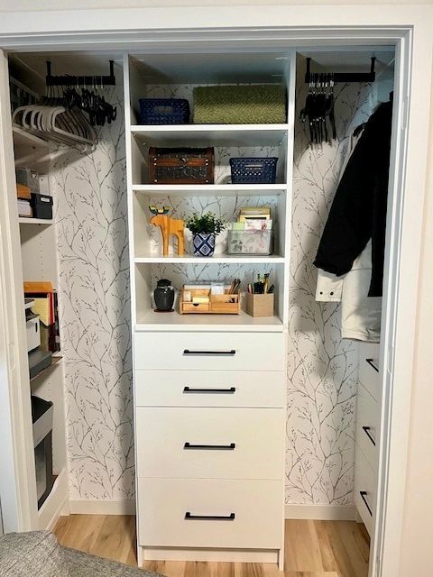 White closet organizer with shelves, drawers, and hanging clothes on both sides