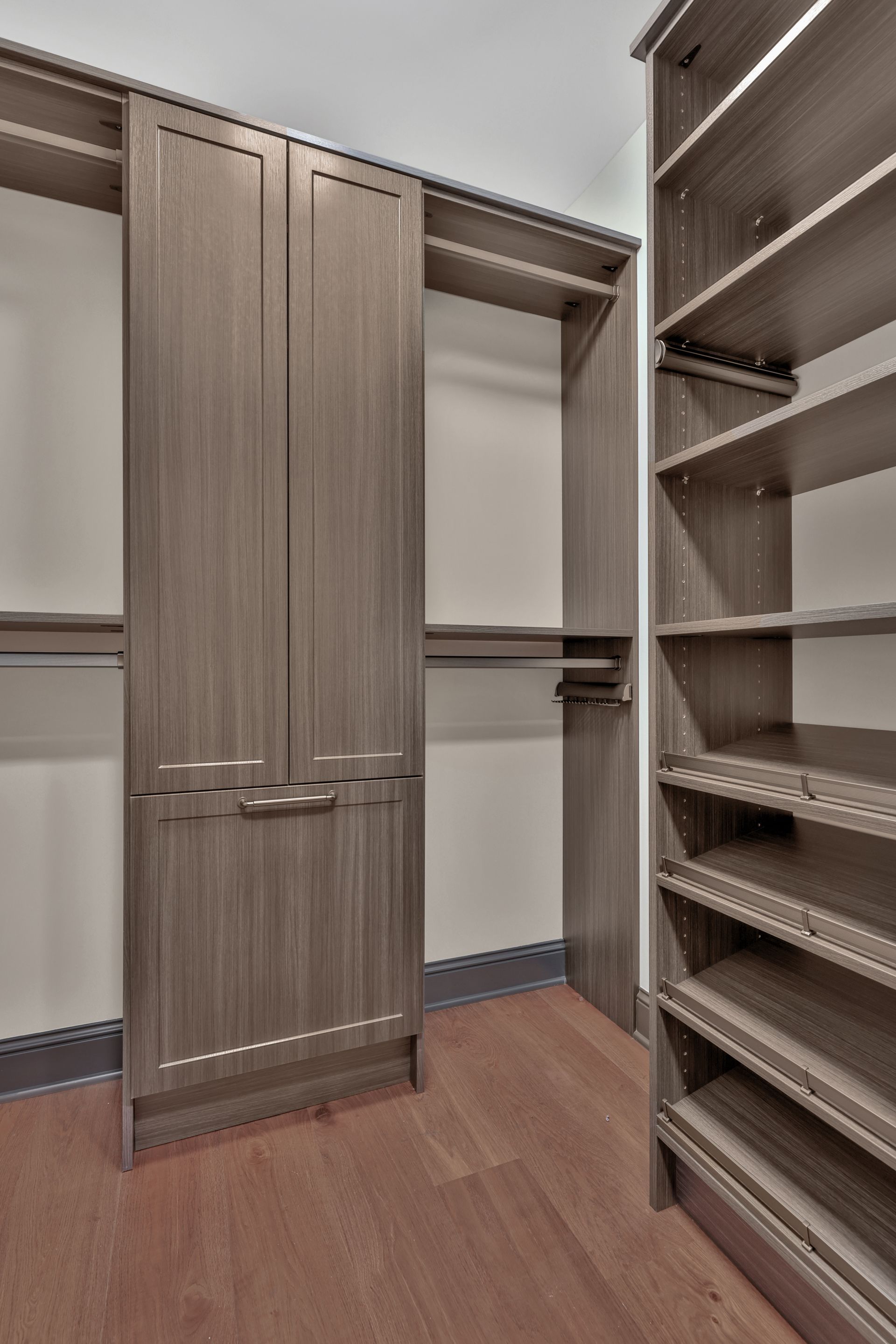 Walk-in closet with wood shelves, hanging rod, and a paneled door
