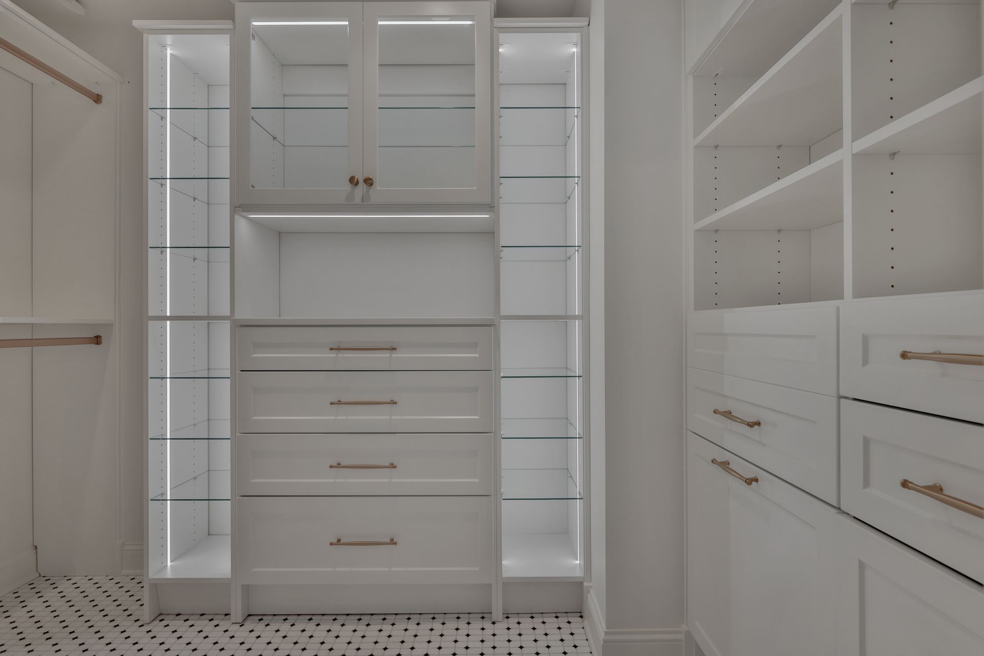 White walk-in closet with built-in shelves, drawers, and hanging storage.
