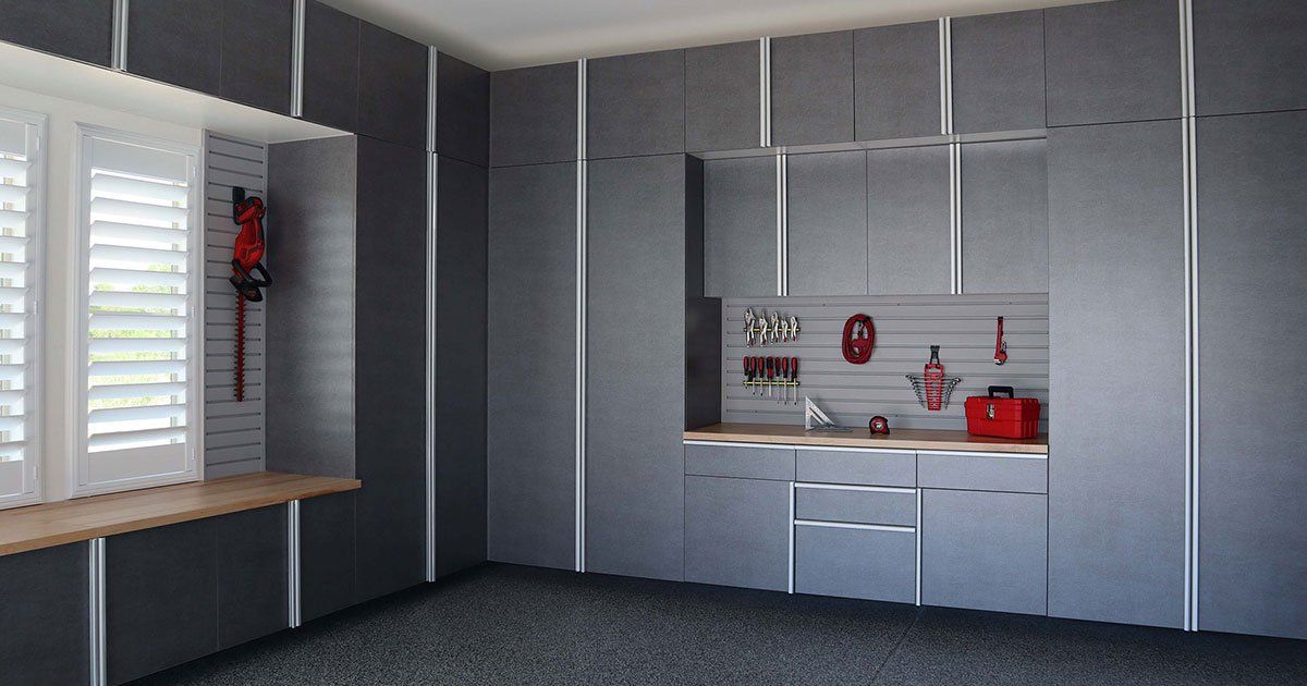 a garage with basalt cabinets and a stainless steel refrigerator