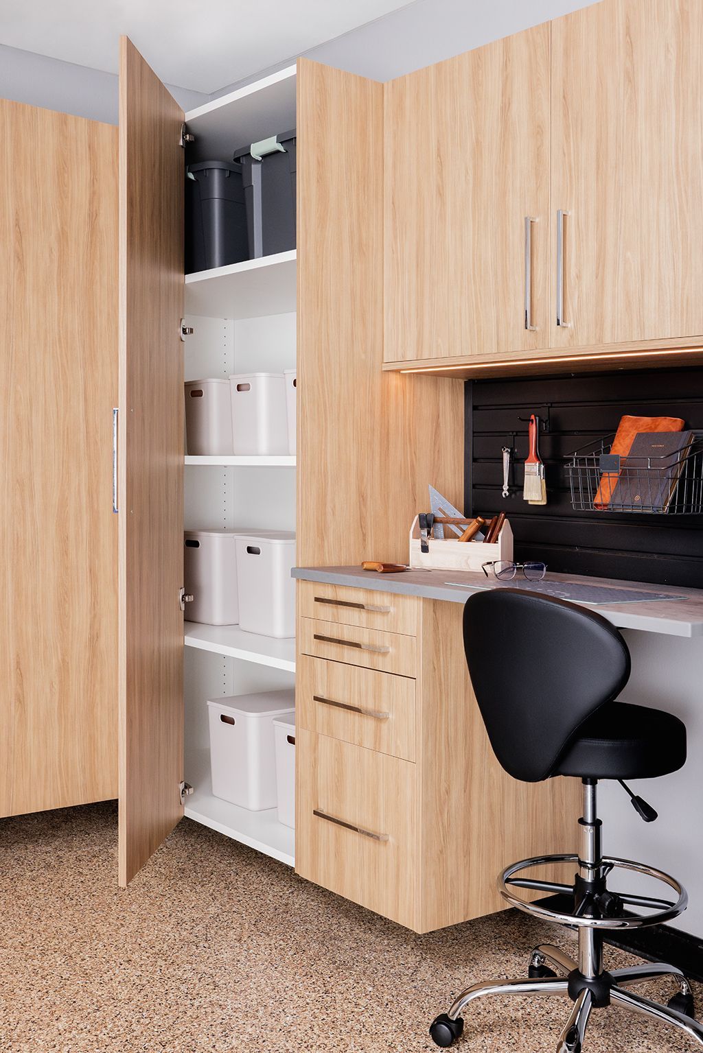 A garage with wooden cabinets, a workbench, and an open door