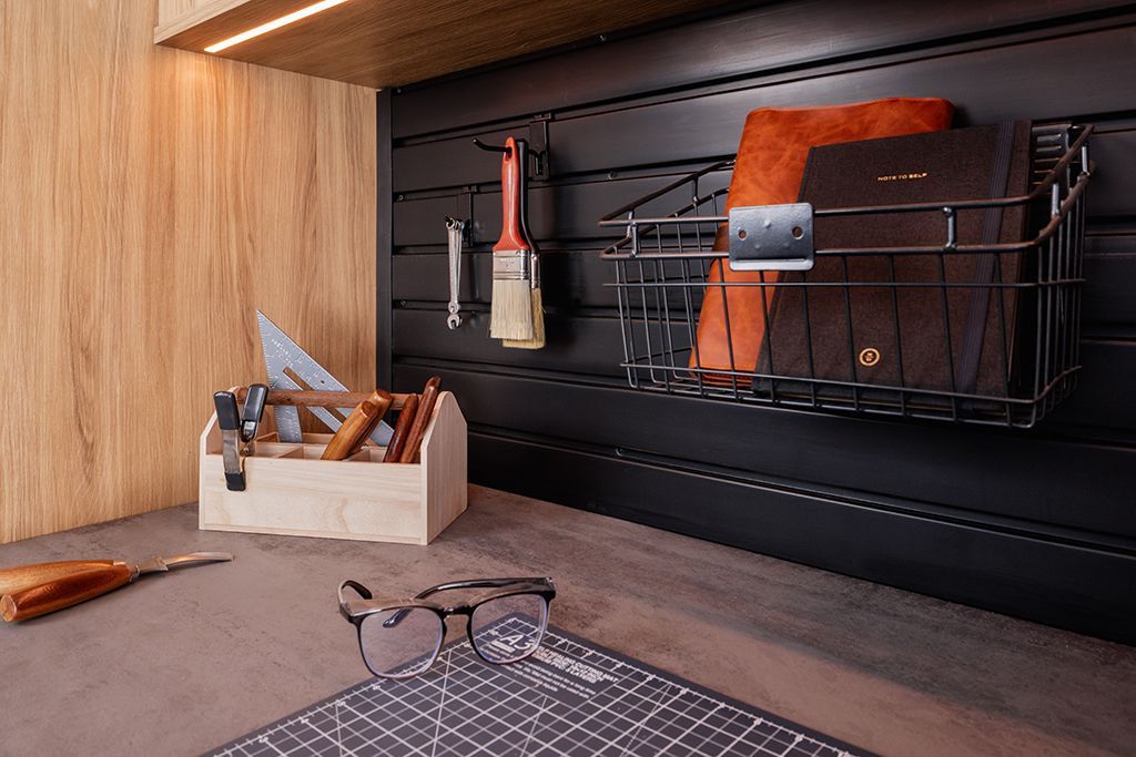A garage with a wood cabinets and slatwall organizers
