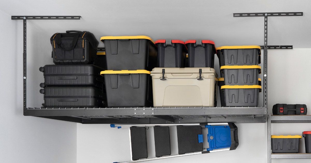A shelf in a garage filled with boxes and luggage.