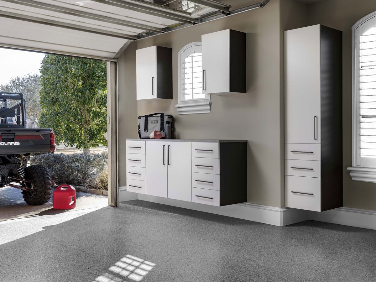 A truck is parked in a garage with lots of cabinets.