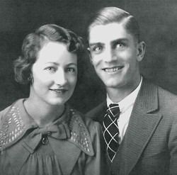 Black-and-white portrait of a smiling couple in formal attire