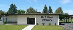 Small white mortuary building with sign reading “Bert’s Funeral Mortuary” and a front walkway